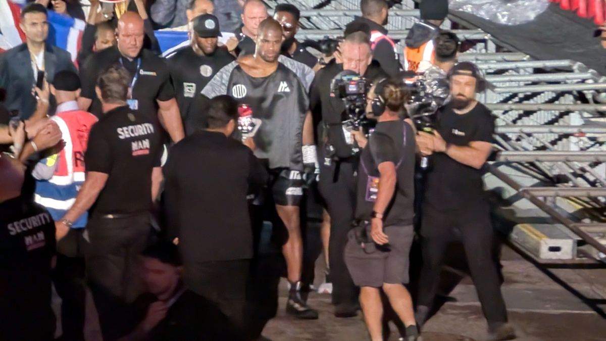 Daniel Dubois walking out at Wembley surrounded by his team, championship belt held aloft behind him