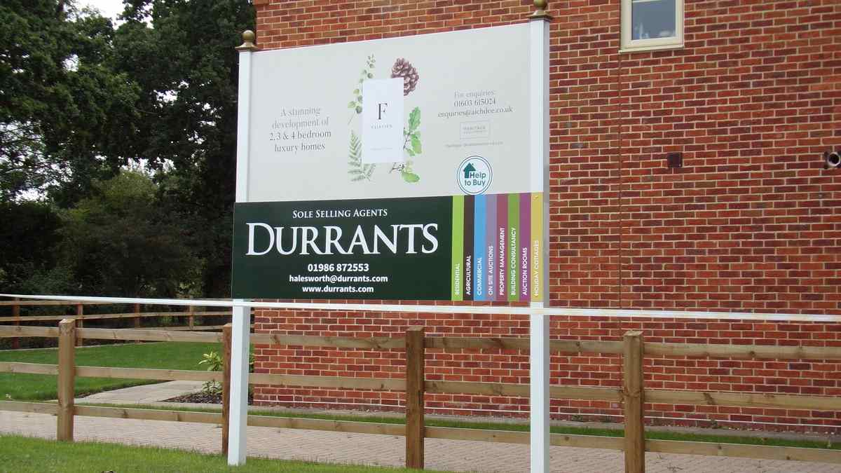 Estate agent sale board outside a new UK housing development